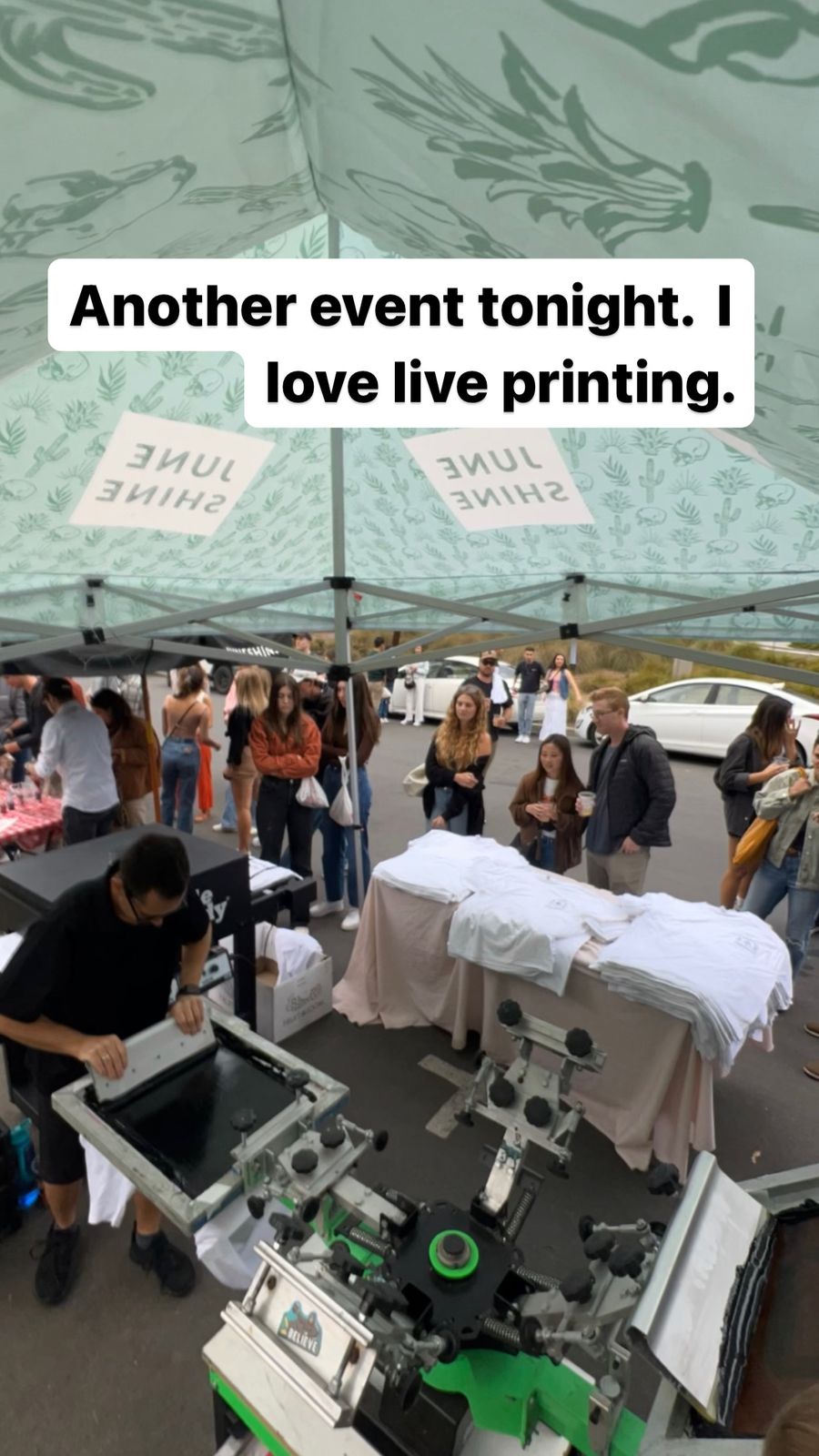 Guests watching custom merch get printed live at a San Antonio event